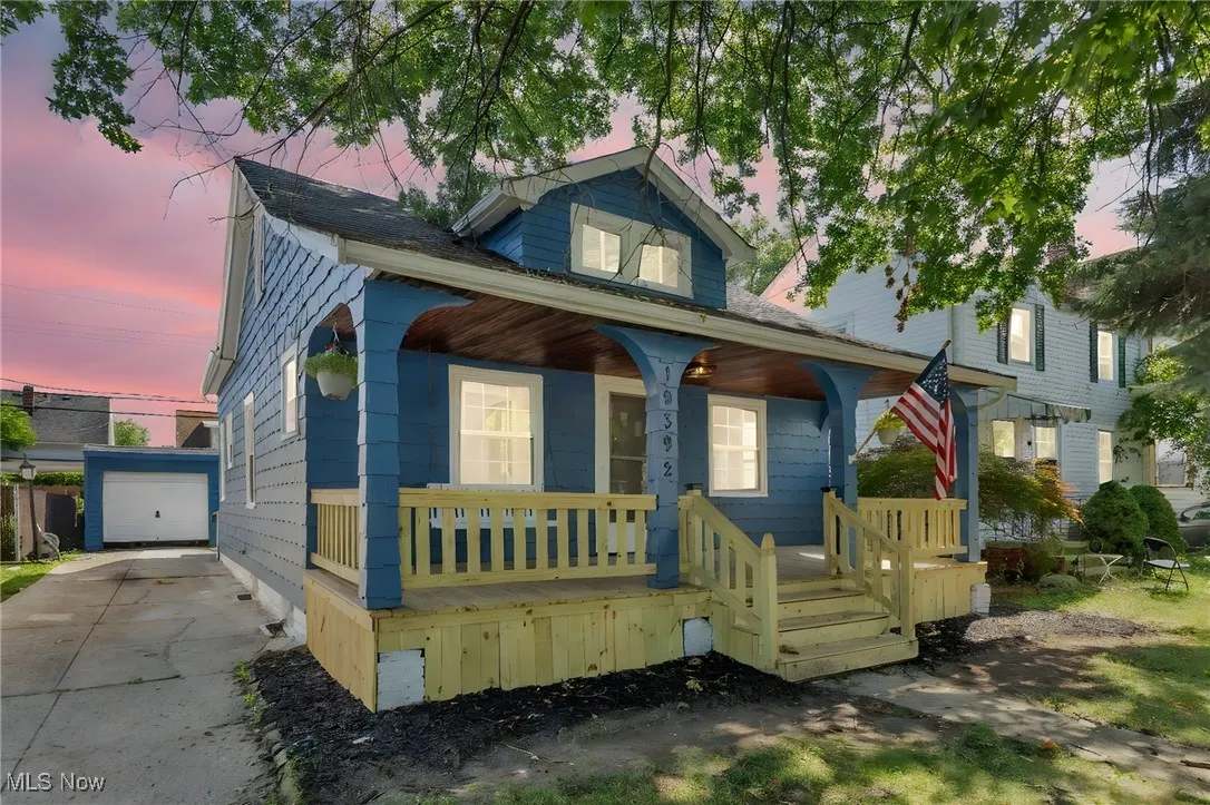 Bungalow-style house featuring covered porch, an outdoor structure, and a garage