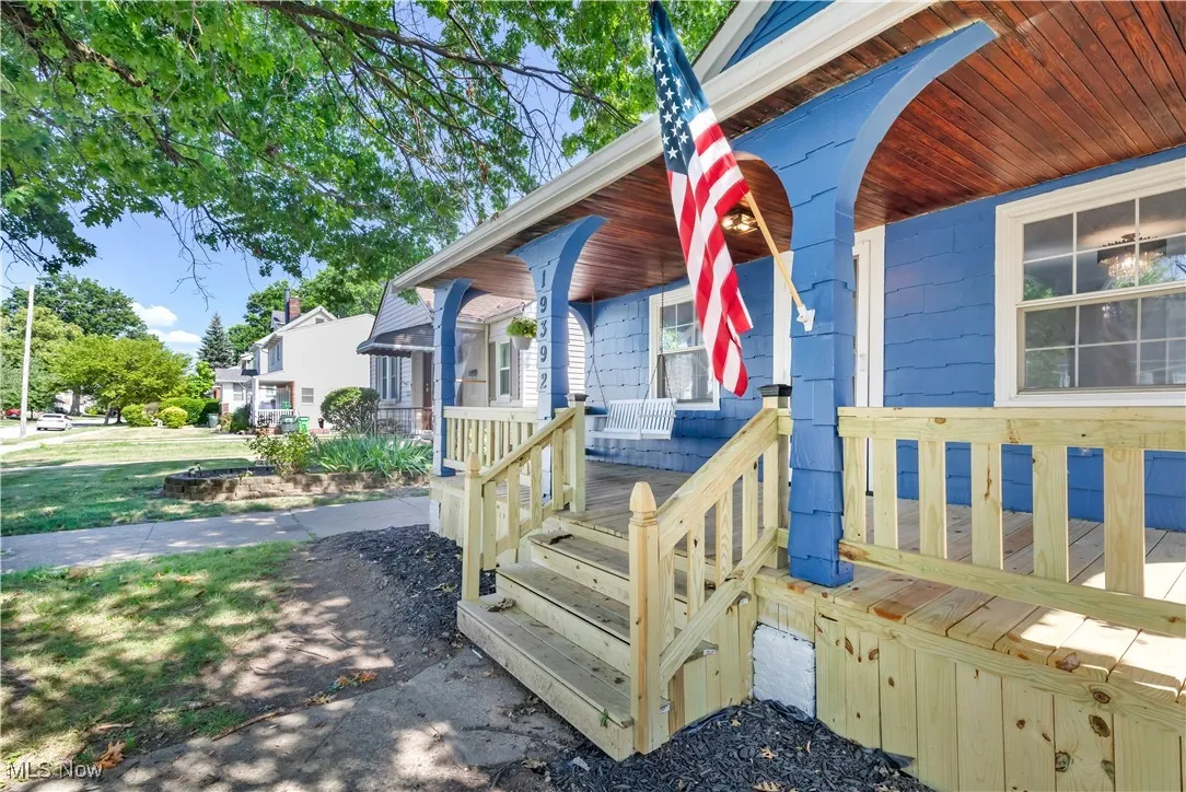 Doorway to property featuring covered porch and a residential view