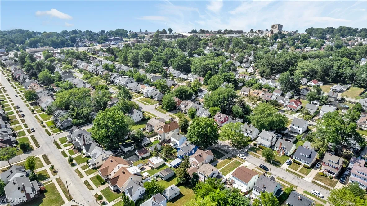 Aerial view of property and surrounding area featuring nearby suburban area