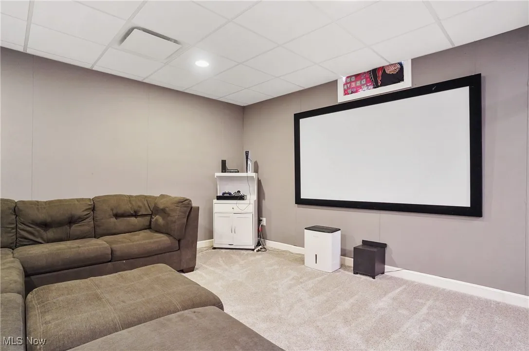 Home theater room featuring a drop ceiling, light carpet, and recessed lighting