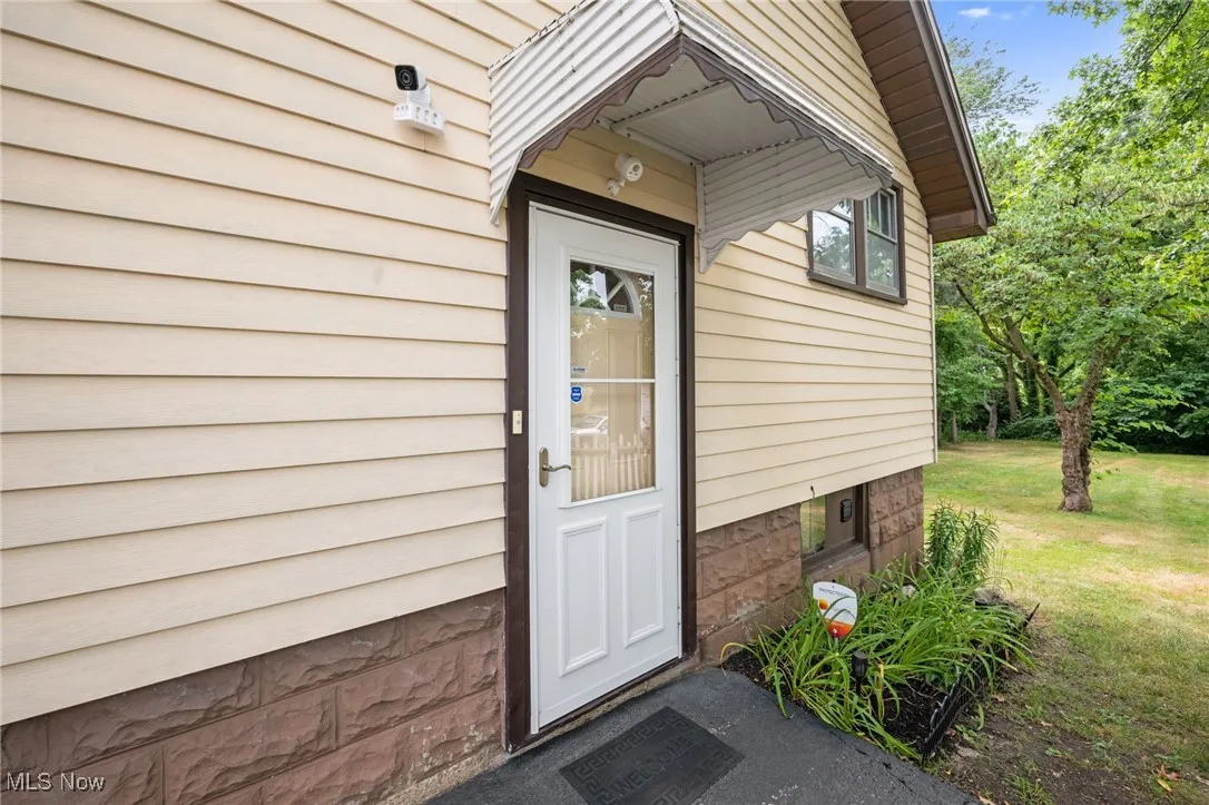Doorway to property featuring a lawn