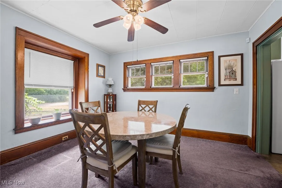 Dining room with a ceiling fan and ornamental molding