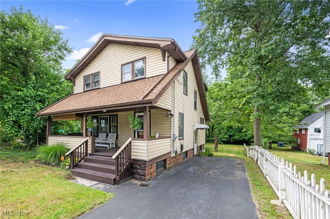 View of front of home with covered porch, a shingled roof, and driveway