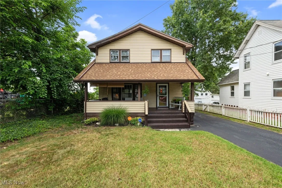 View of front of property with a shingled roof, a porch, and driveway