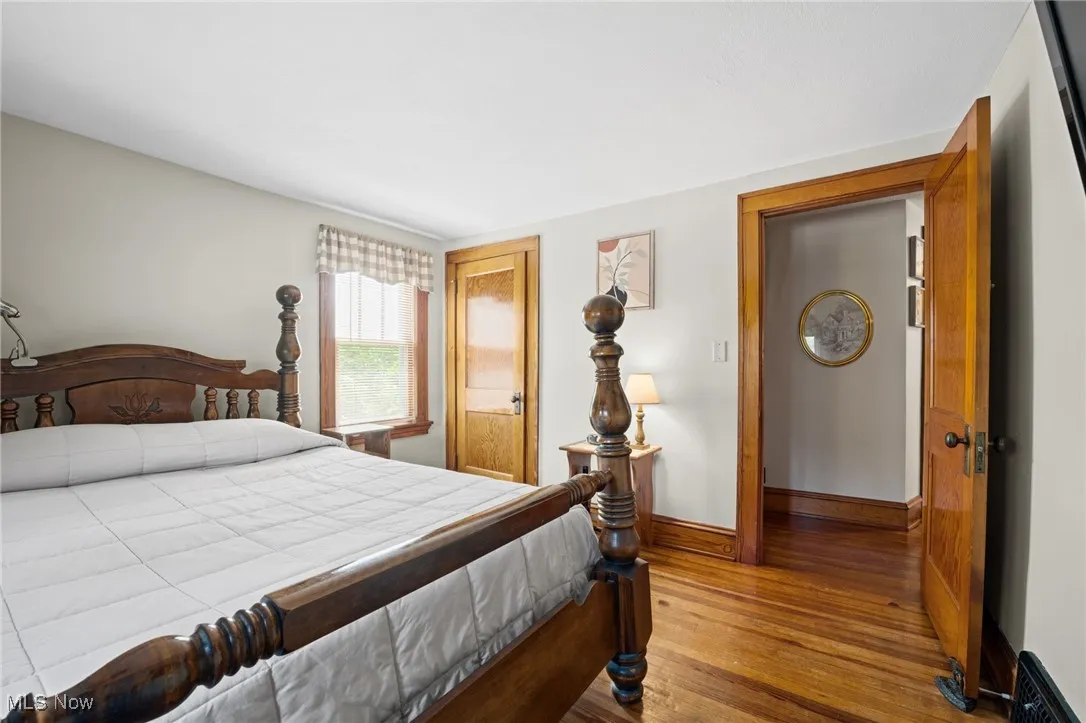 Bedroom with wood finished floors and a closet
