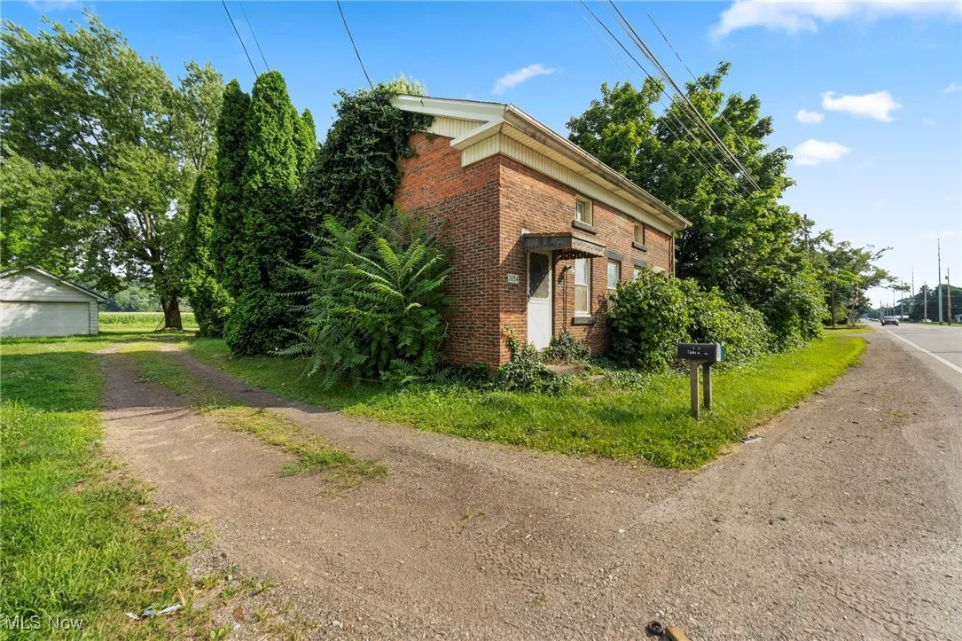 View of home's exterior featuring brick siding and driveway