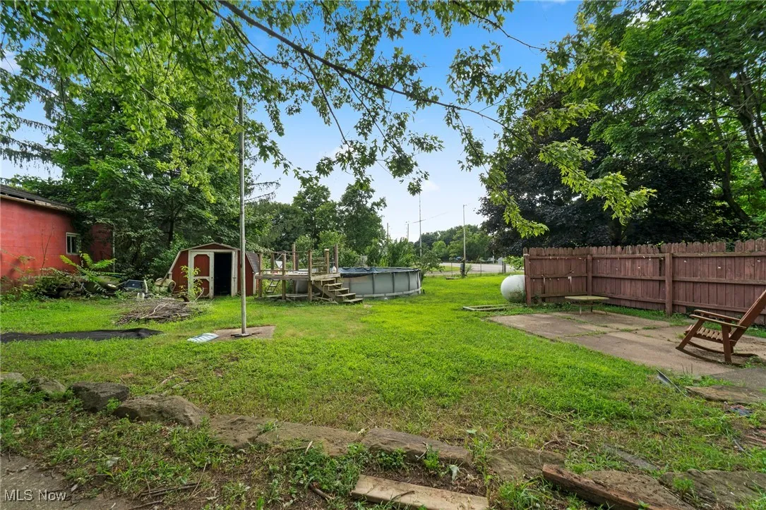 View of yard featuring a storage shed and a covered pool