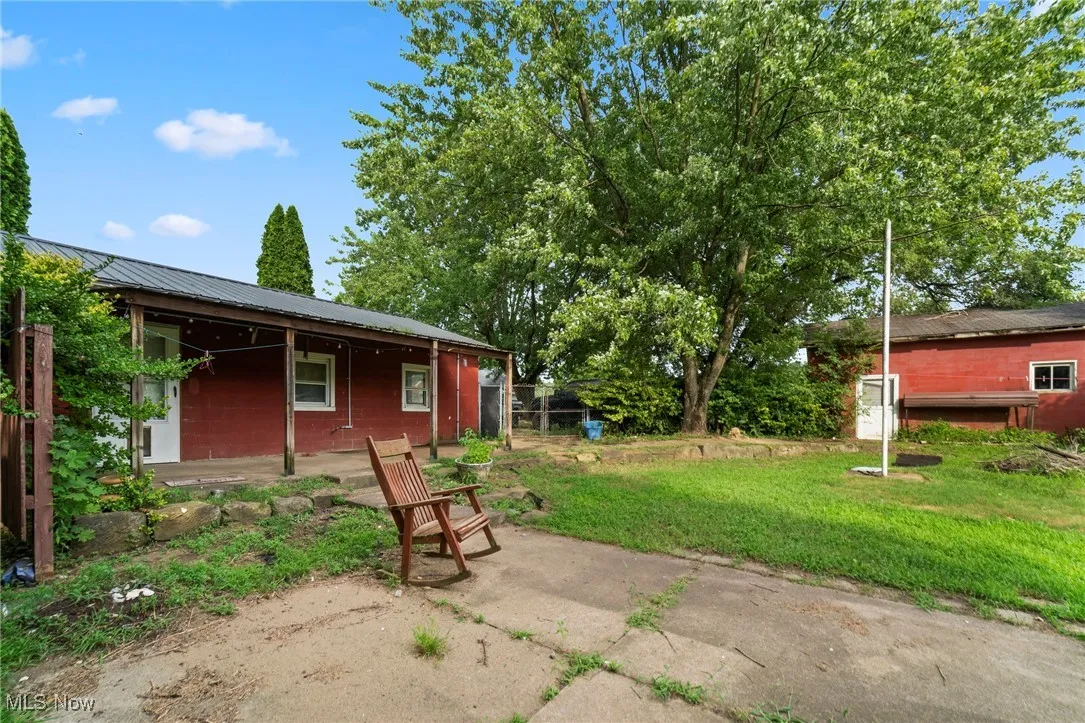 View of grassy yard with a patio area