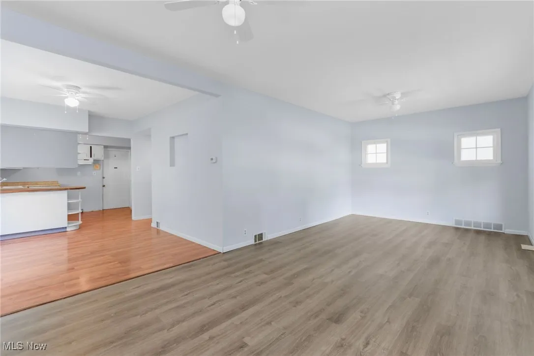 Unfurnished living room with ceiling fan and light wood-style flooring