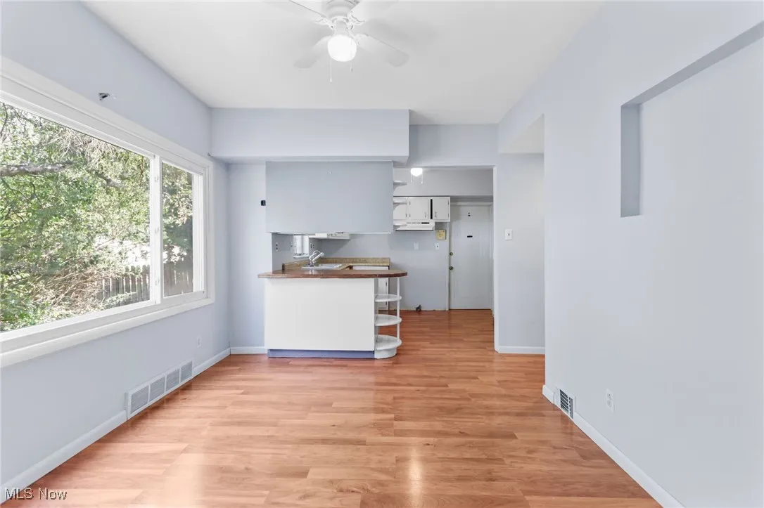 Kitchen with light wood-style floors, a ceiling fan, white cabinetry, and open shelves