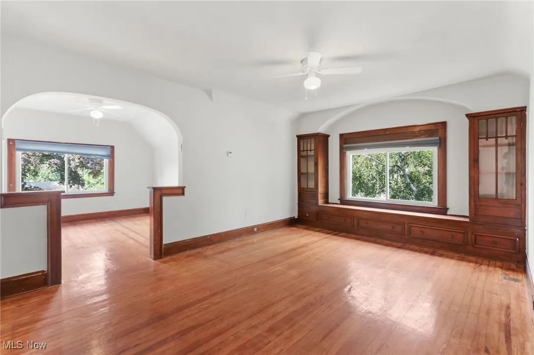 Spare room with a ceiling fan, wood-type flooring, and plenty of natural light