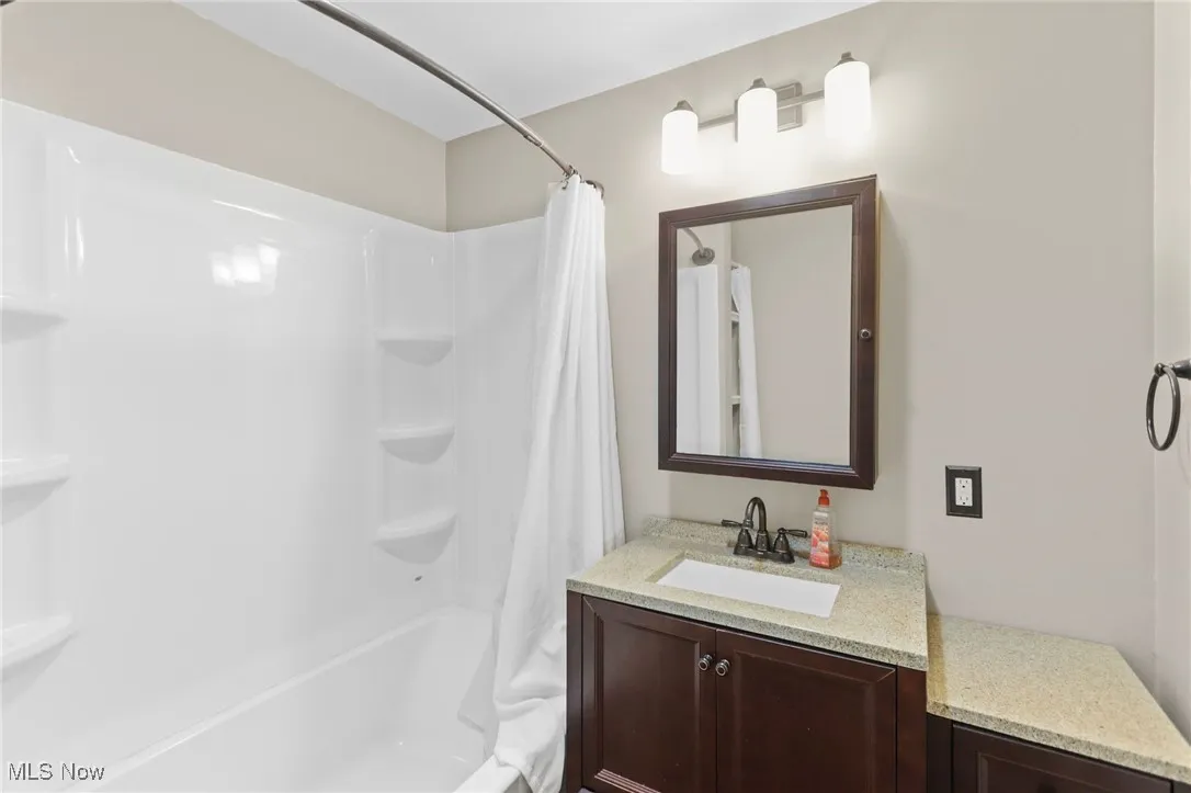 Full bathroom with vanity and shower / bath combination with curtain