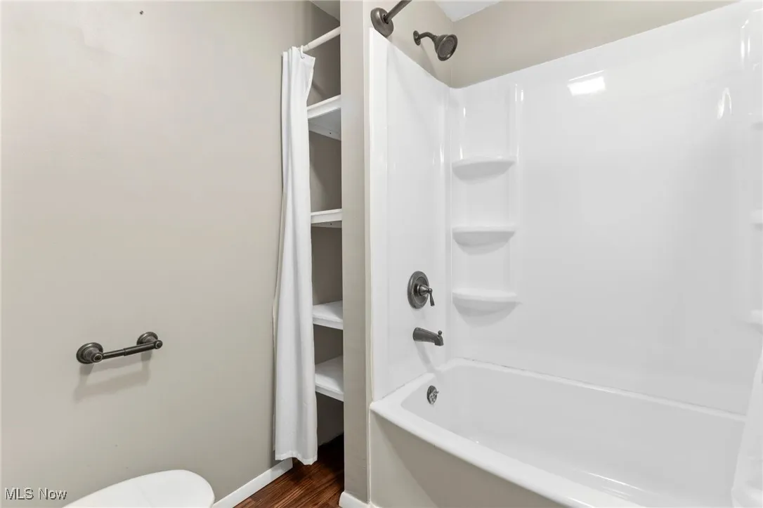 Bathroom featuring shower / bath combo with shower curtain and wood finished floors