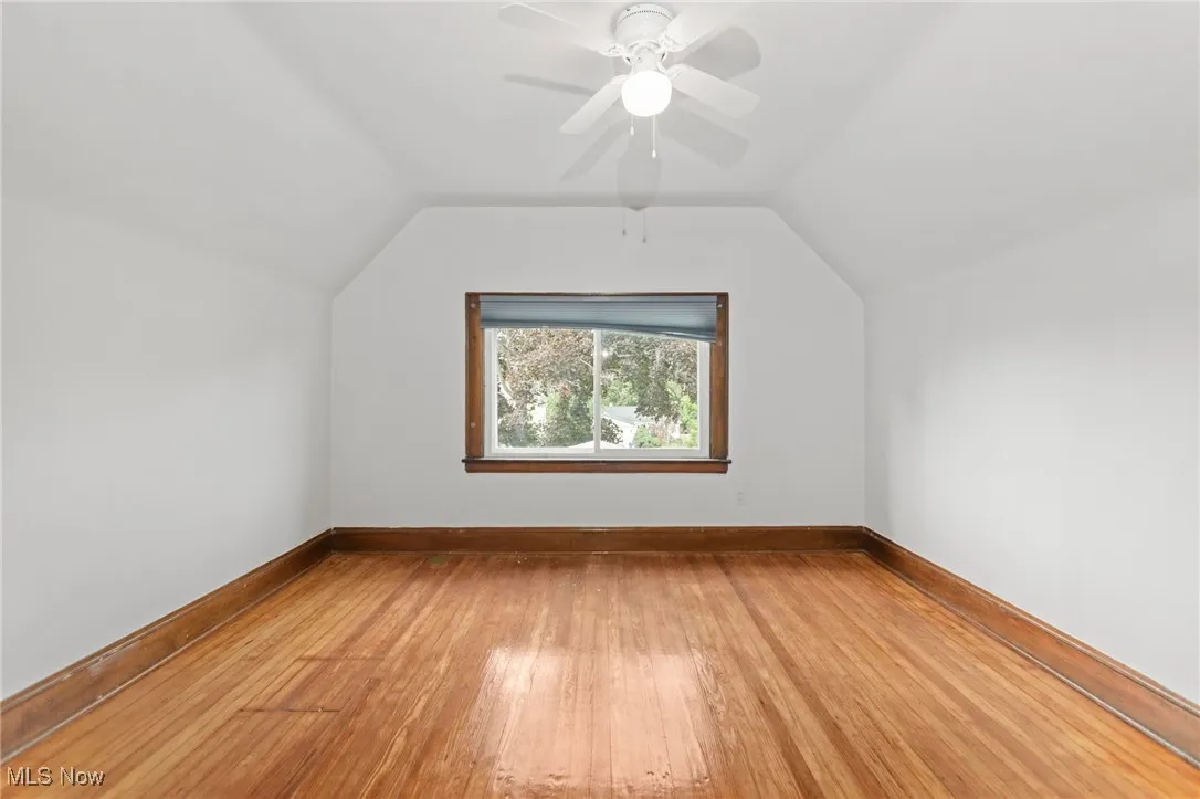 Bonus room with vaulted ceiling, light wood-type flooring, and a ceiling fan