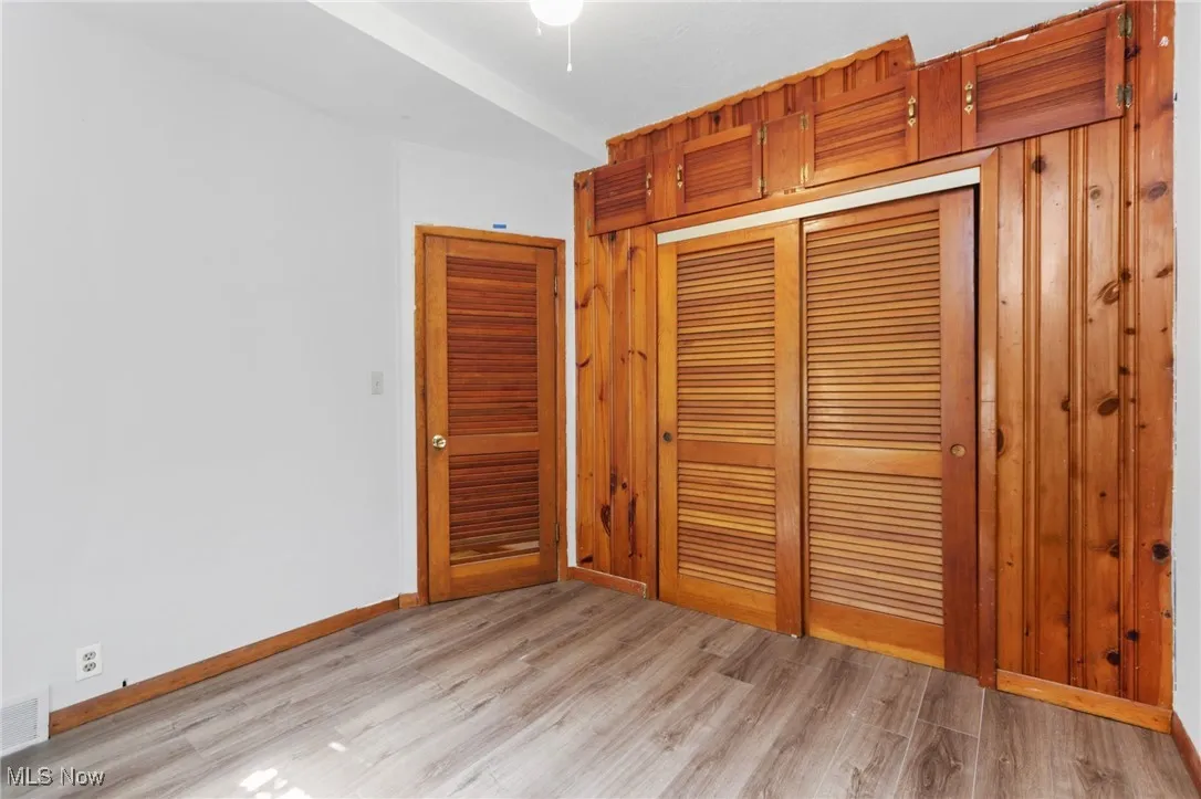 Unfurnished bedroom with light wood finished floors and a closet