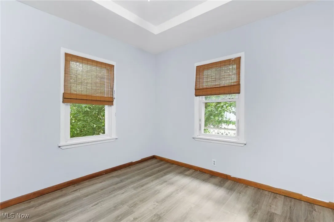 Empty room featuring baseboards and light wood-type flooring