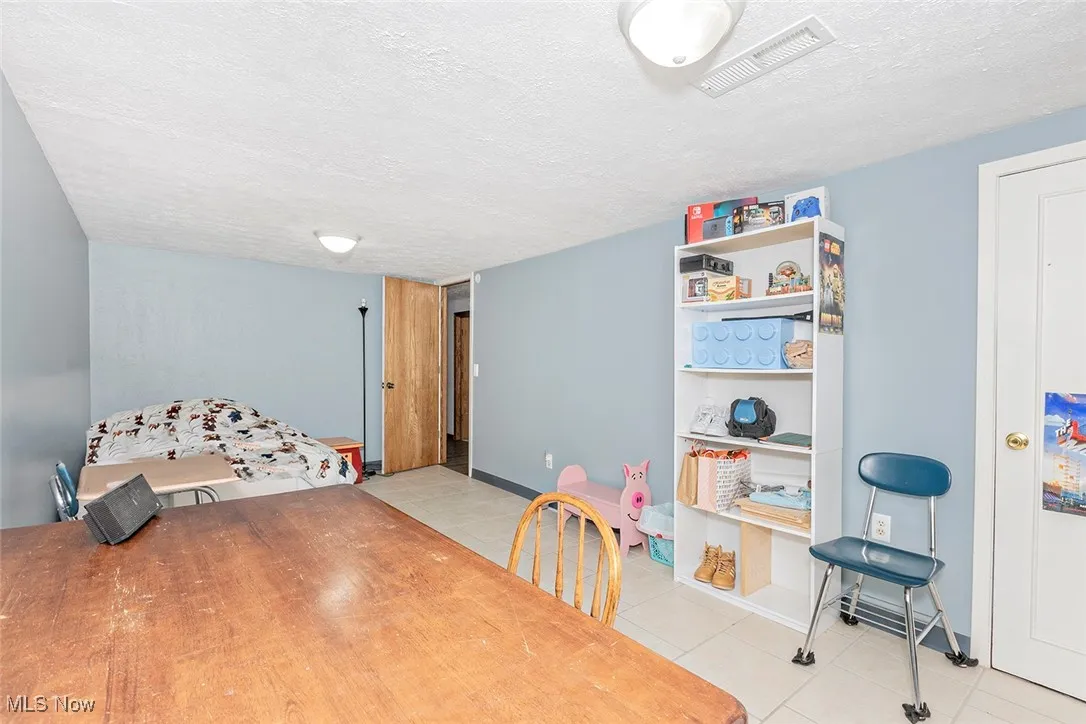 Rec room featuring a textured ceiling and tile patterned floors