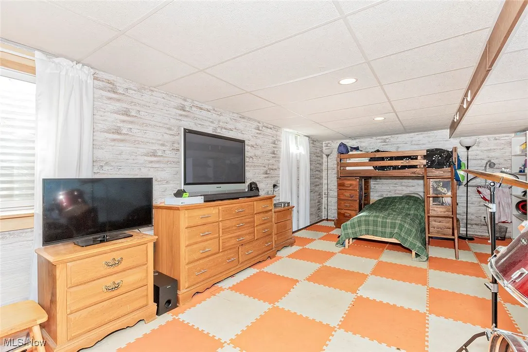Bedroom with a drop ceiling, light flooring, and recessed lighting