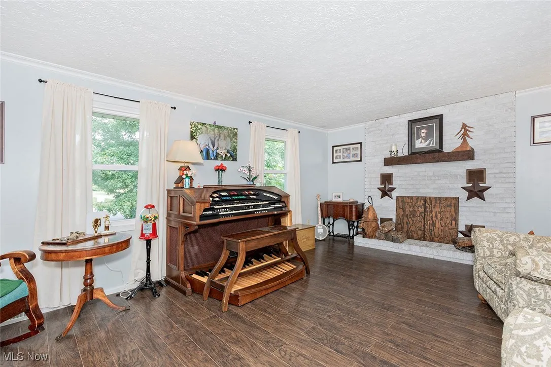 Sitting room featuring ornamental molding, wood finished floors, and a textured ceiling