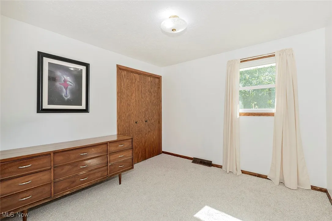 Unfurnished bedroom featuring light carpet and a closet