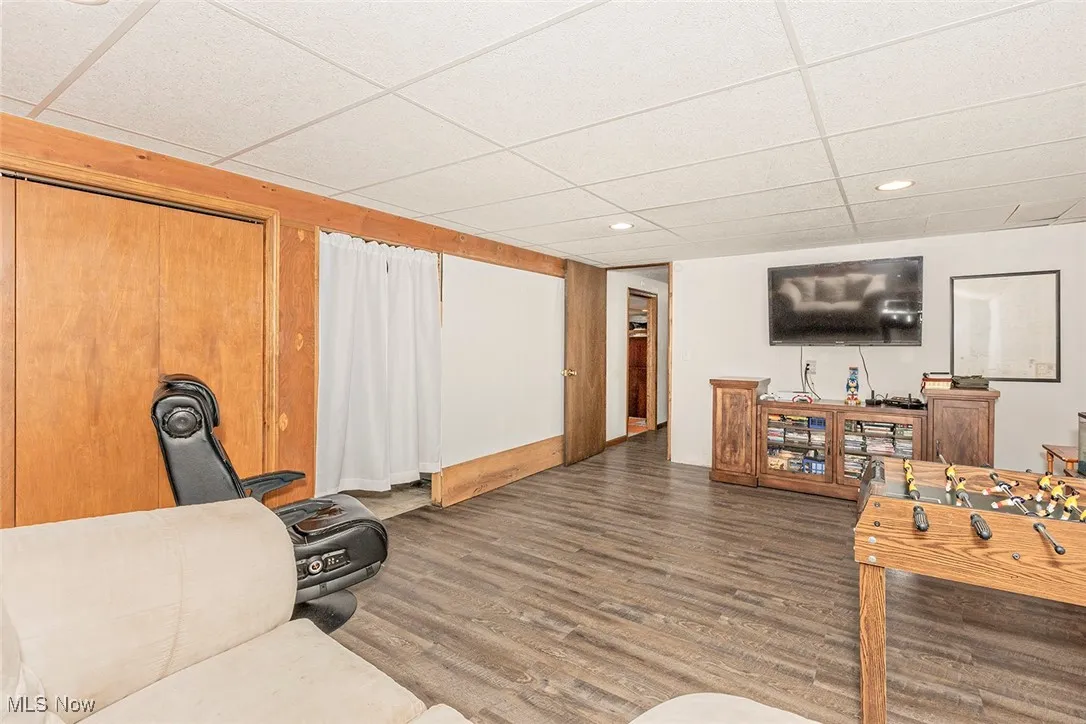 Living area with a paneled ceiling, wood finished floors, and recessed lighting