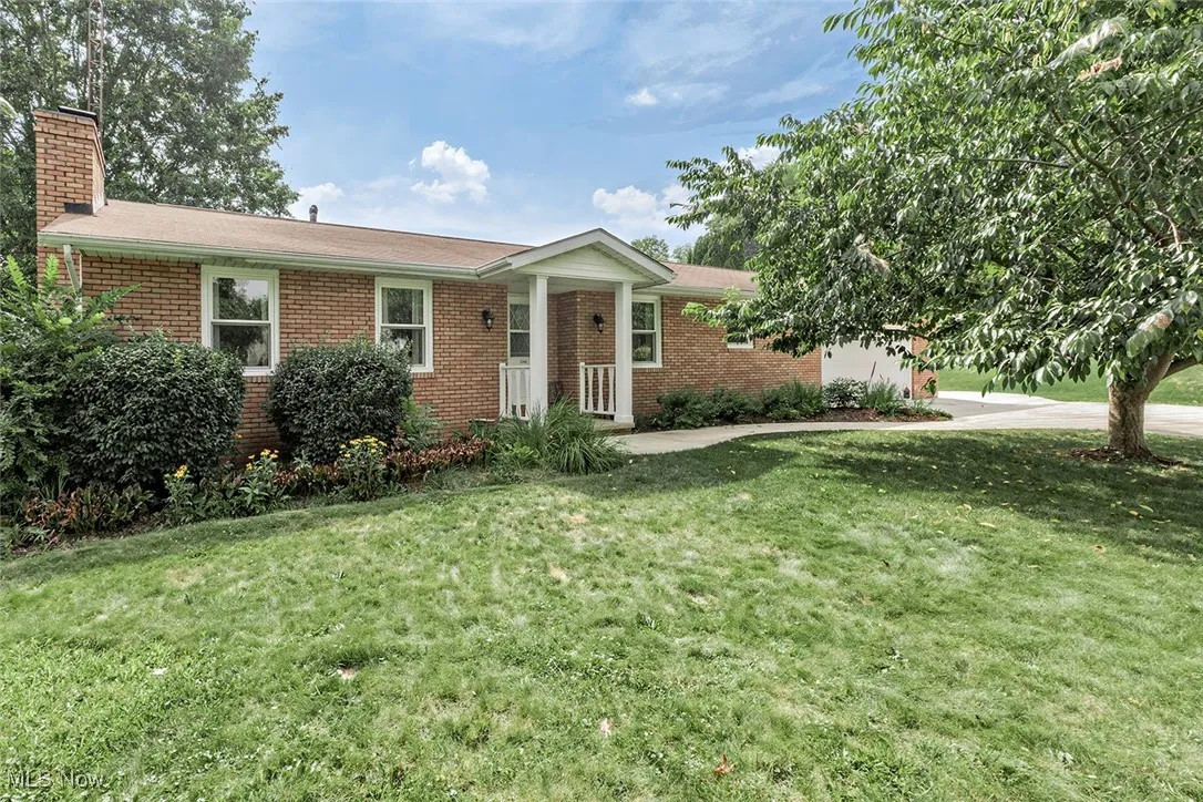 Single story home featuring a front lawn, brick siding, and a chimney