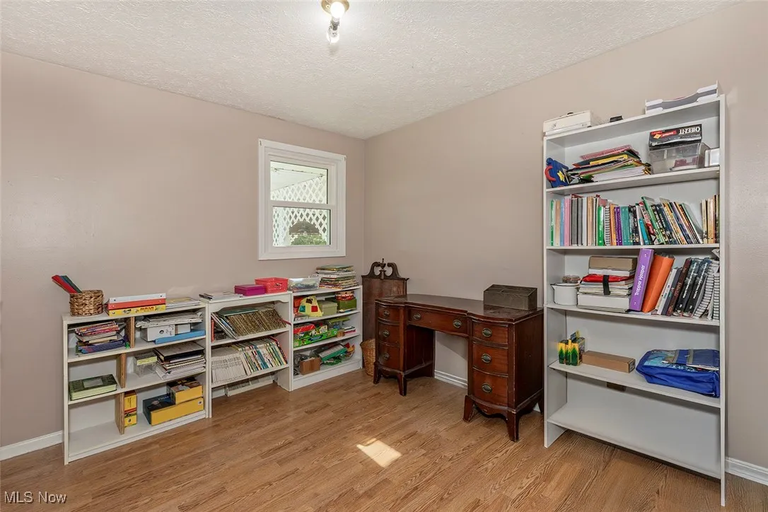 Office with a textured ceiling and wood finished floors