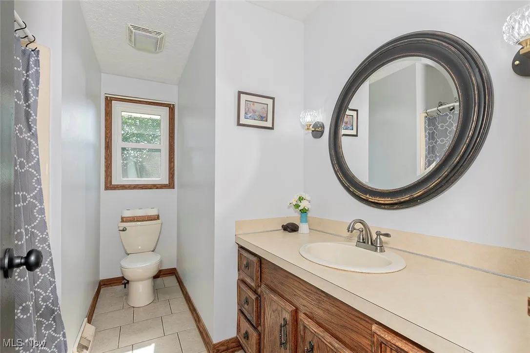 Bathroom featuring vanity, tile patterned floors, and a textured ceiling