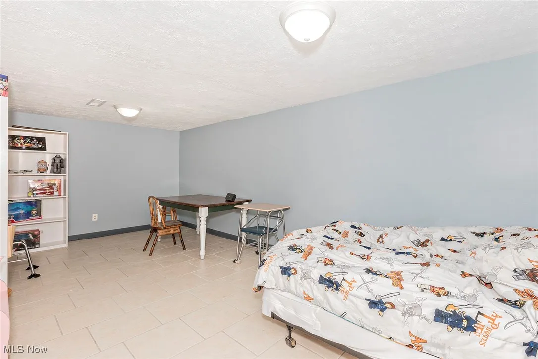 Bedroom featuring a textured ceiling and light tile patterned floors