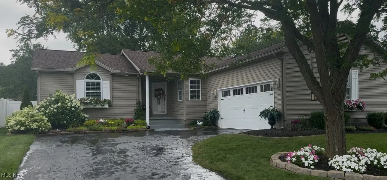 Single story home with driveway, an attached garage
