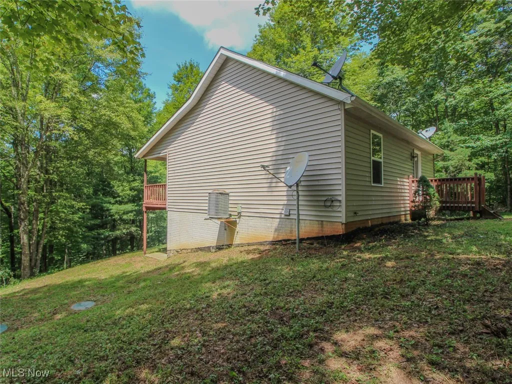 View of home's exterior with a lawn and a wooden deck