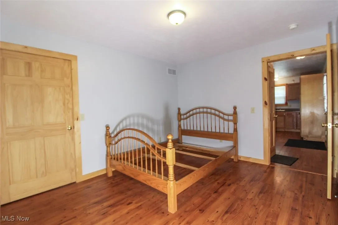 Bedroom with wood finished floors and baseboards