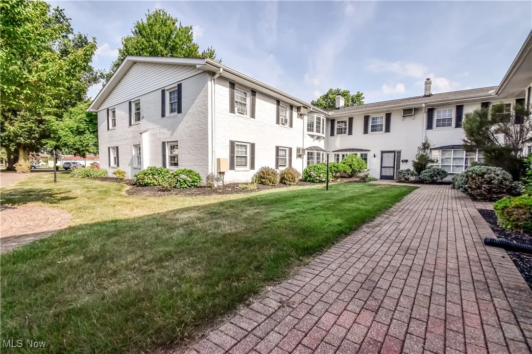 Colonial house featuring a front yard and brick siding