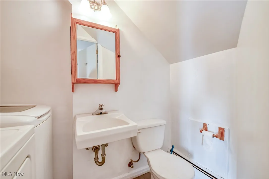 Half bath with washer and clothes dryer and vaulted ceiling