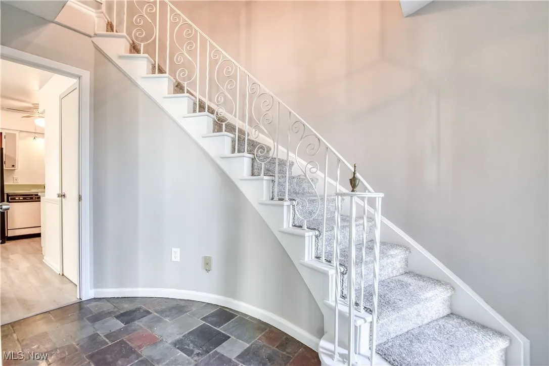 Staircase featuring stone tile flooring and a ceiling fan