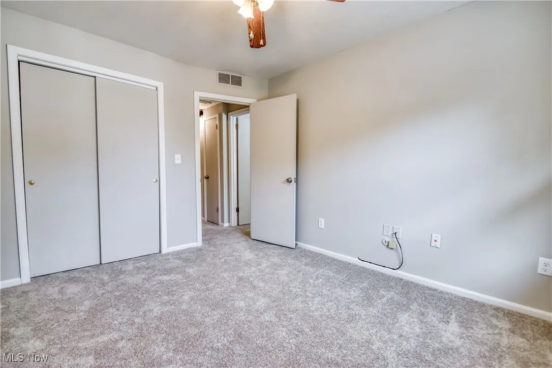 Unfurnished bedroom with carpet flooring, a closet, and ceiling fan