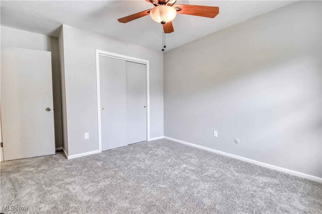 Unfurnished bedroom with carpet flooring, a closet, and a ceiling fan