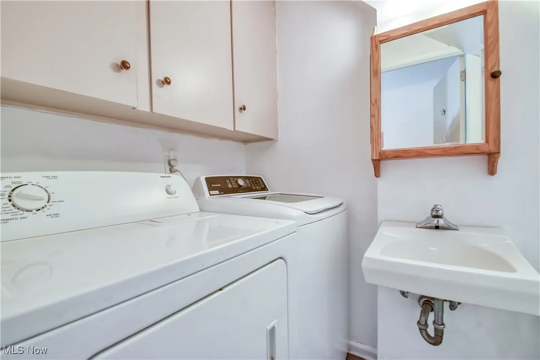Laundry area featuring independent washer and dryer and cabinet space