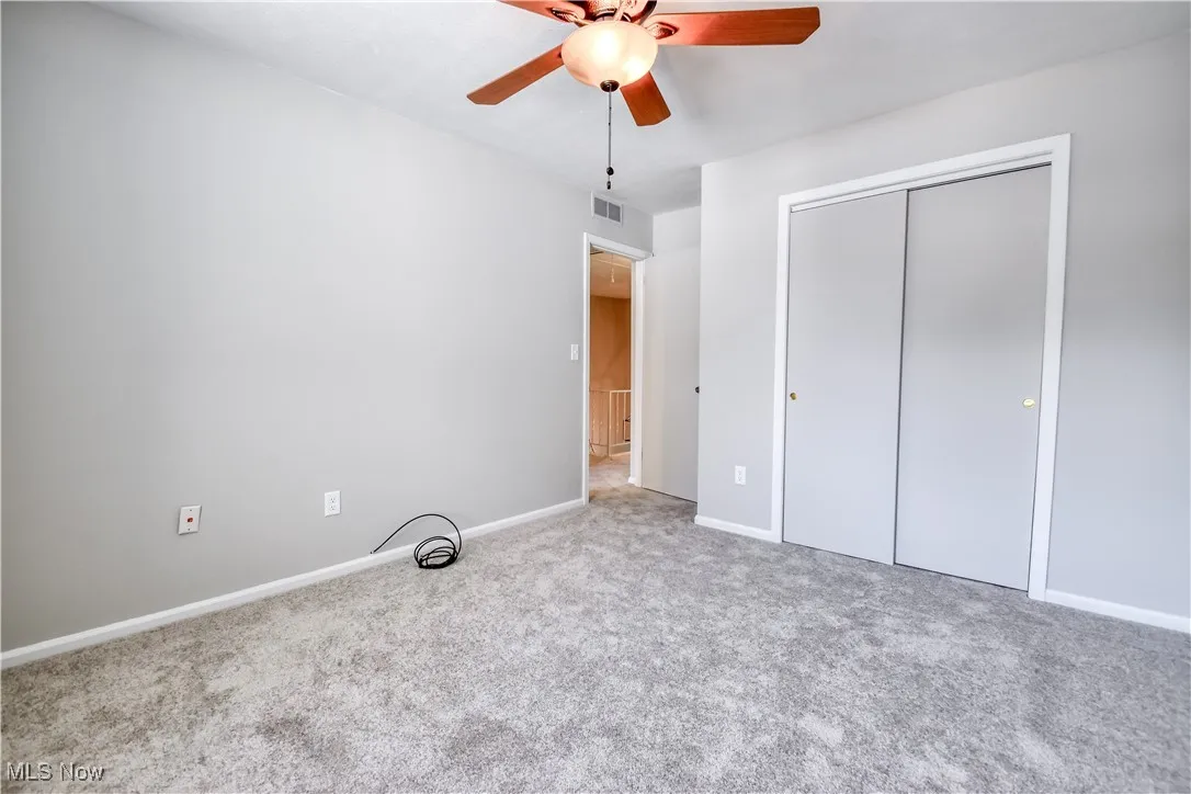 Unfurnished bedroom with carpet flooring, a closet, and ceiling fan