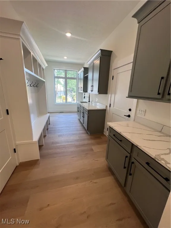 Mudroom featuring light wood-style flooring and a sink