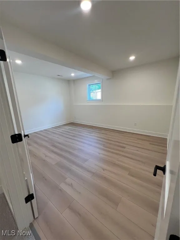 Basement with light wood-style flooring and recessed lighting
