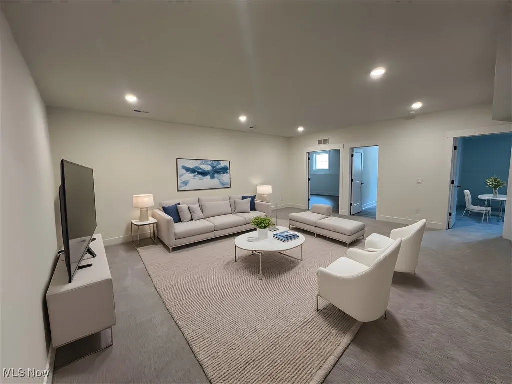 Carpeted living room featuring recessed lighting and baseboards