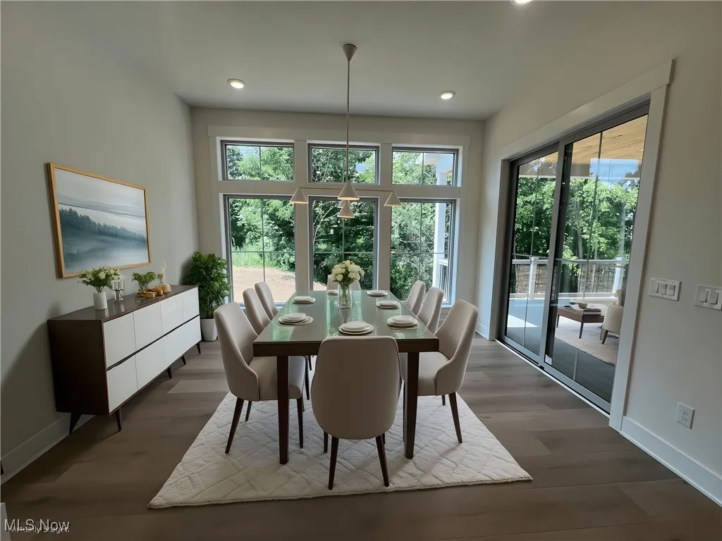 Dining space with dark wood finished floors and recessed lighting