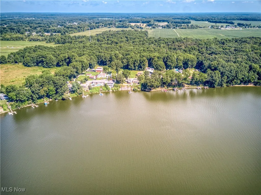 View of property location featuring a forest and a nearby body of water