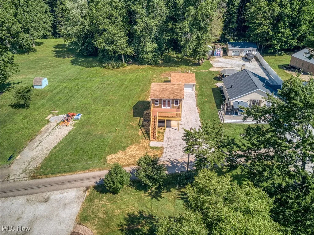 Aerial view of property and surrounding area featuring a forest