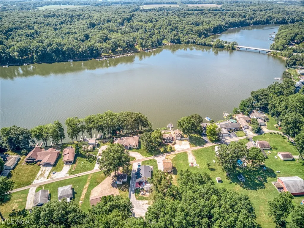 Aerial view of residential area with a nearby body of water and a forest