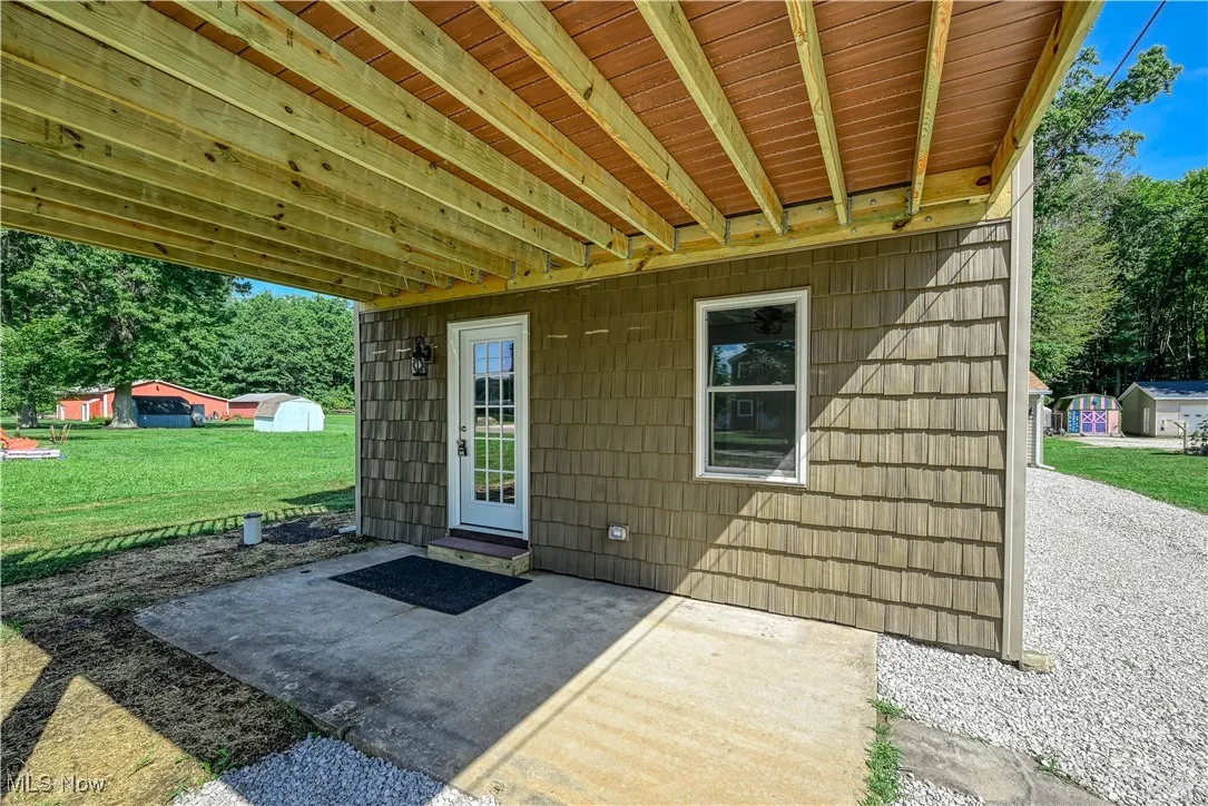 Property lower entrance featuring a patio area and a lawn