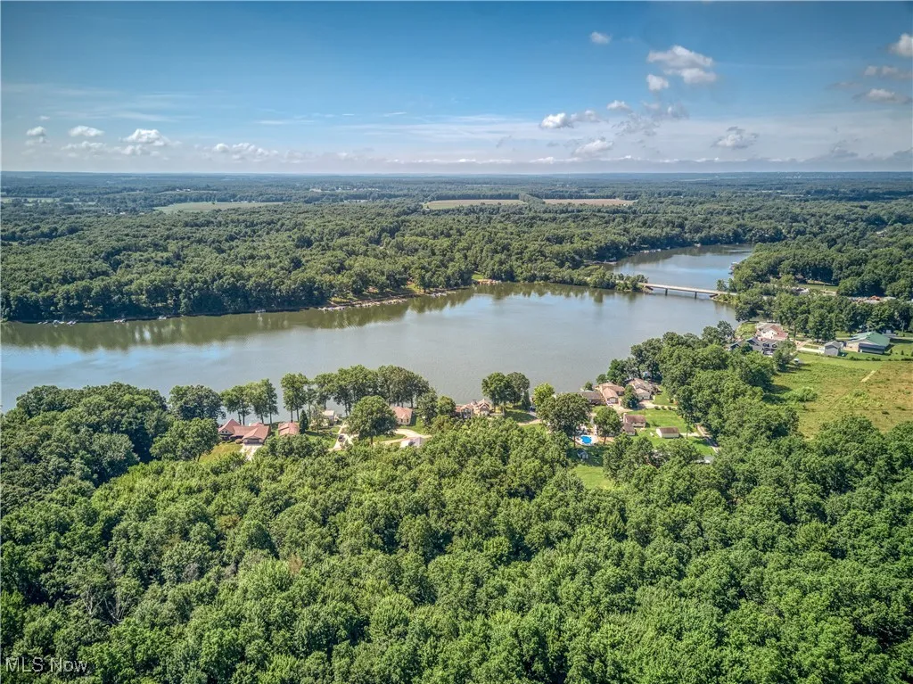 Drone / aerial view of a heavily wooded area and a large body of water