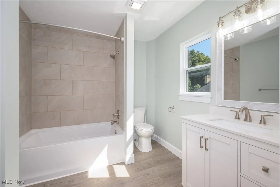Full bath with vanity,  shower combination, and wood finished floors