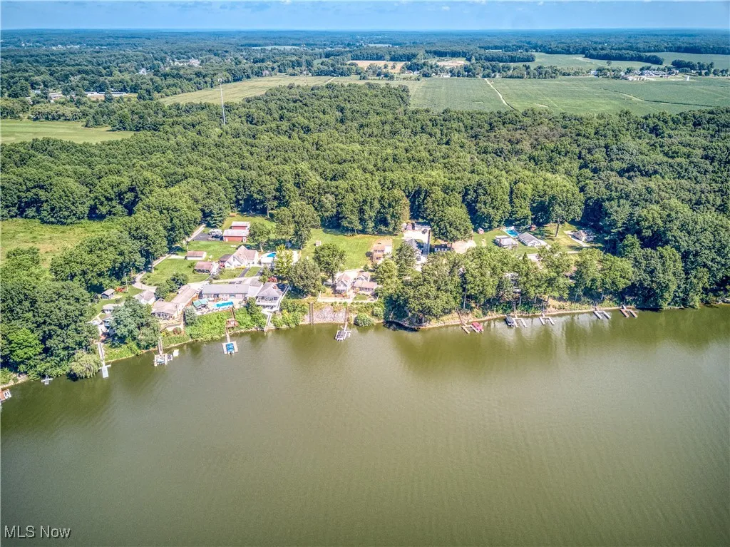 Aerial view of property's location with a forest and a nearby body of water